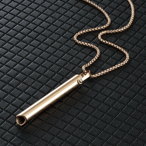 Detailed view of golden mindfulness breathing pendant on a black textured background