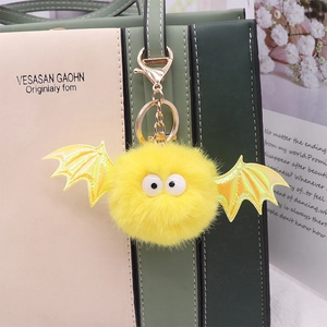Yellow faux mink fur bat keychain charm with laser wings on a stylish handbag handle