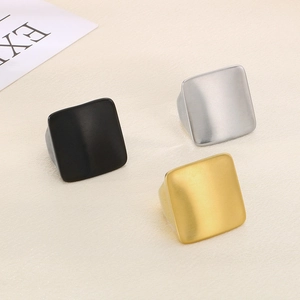 Close-up of matte square titanium steel rings in gold, silver, and black finish