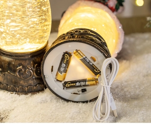 Close-up of vintage Christmas lantern base showing dual AA battery and USB power options