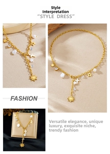 Dettaglio della collana a Y dorata con perle, stelle e ciondoli a croce
