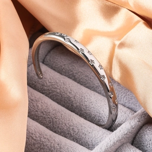 Macro shot of titanium steel star bangle with sparkling zircon inlays on gray velvet