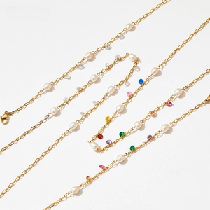 Detail of gold chain necklace with colorful faceted gemstones and white pearls texture