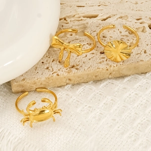 Three 18k gold butterfly and ocean themed adjustable rings on a minimalist stone base