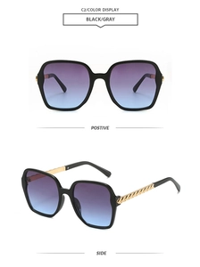 Detail view of large polygon sunglasses with black/gray gradient lenses and gold chain temples