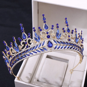 Close-up of golden Baroque bridal crown with blue crystals in a white jewelry gift box