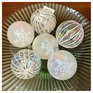 Detailed view of iridescent white Christmas ornaments with snowflake and stripe textures