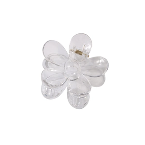 Macro shot of a translucent flower-shaped hair claw clip with a gold metal spring