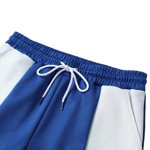 Detail of elastic waist with white drawstring on blue and white jogging pants