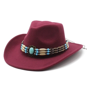 Détail d'un chapeau de cowboy en feutre avec ruban perlé ethnique et pierre turquoise
