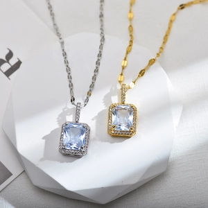 Macro detail of silver and gold square zircon pendants on white geometric props