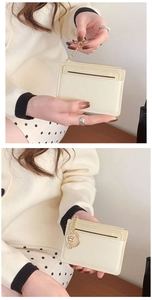Detail of beige striped coin purse featuring a gold chain and secure top zipper closure