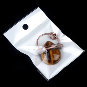 Vintage bronze tiger eye teardrop pendant with wire wrapped natural stone on black background