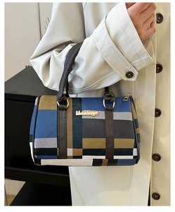 Détail du sac à main à carreaux multicolores avec poignée marron foncé et finitions dorées