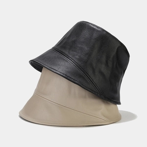 Texture detail of black and khaki PU leather bucket hats in a minimalist stacked view
