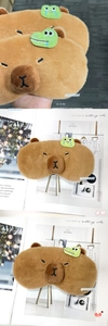 Detail of plush brown Capybara sleep mask with cute cartoon frog embroidery on top