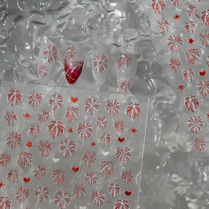 Detail of red and white firework nail art stickers on long stiletto nails