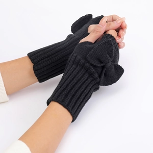 Close-up of black knitted fingerless gloves with cute bow detail and warm wrist design