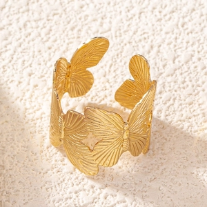 Close-up of a golden butterfly ring with detailed wing textures and an open design