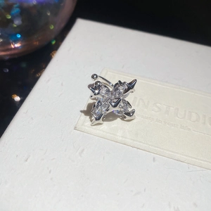 Macro shot of silver four-pointed star ear cuff with sparkling cubic zirconia stones