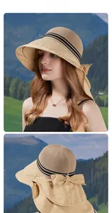 Detail of khaki sun hat with wide brim, black stripes and a large decorative bow