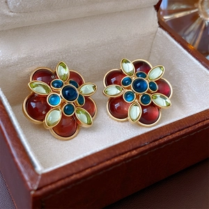 Close-up of vintage floral earrings with colorful stones in a brown leather jewelry box
