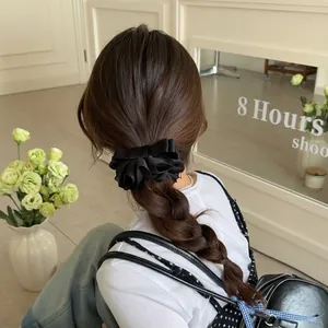 Barrette à nœud en satin noir élégante pour queue de cheval haute portée par un mannequin
