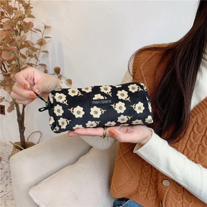 Floral canvas bag with white flowers and zipper used as a stationery or makeup pouch