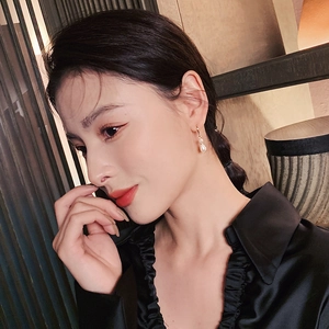 Close-up of golden baroque freshwater pearl drop earrings on a model profile