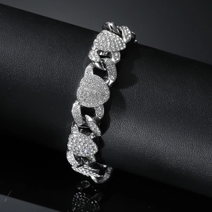 Bracelet cubain argenté avec cœurs en strass sur un présentoir cylindrique noir