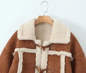 Detail of brown faux suede jacket featuring cream fleece lining and toggle horn buttons