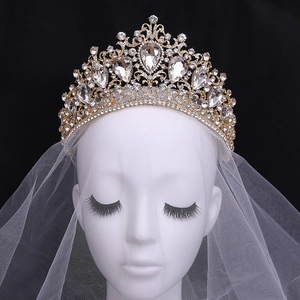 Baroque gold bridal crown with red crystals and white veil on a black background