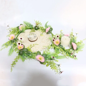 Pink artificial flower garland with woven placemat for elegant wedding table decor