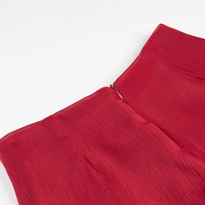 Detail of dark red dress showing pleated texture fabric and invisible zipper closure