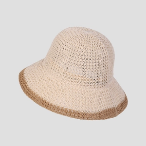 Dettaglio del cappello da sole in maglia traspirante con trama beige e bordo marrone