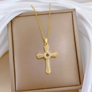 Detail of spinning gold cross necklace with shimmering crystals in a luxury jewelry box