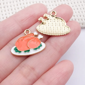 Détail d'un petit pendentif dinde en émail pour bijoux DIY montrant le dos doré