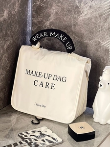 Detail showing the cream makeup bag with durable fabric handles and gold zipper hardware