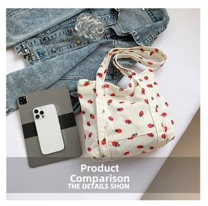 Flat lay of cream corduroy tote bag with red strawberry pattern next to a tablet