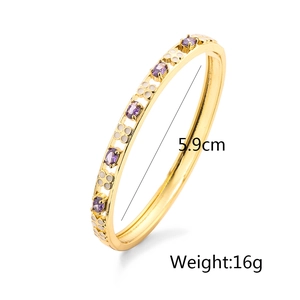 Detalle del brazalete chapado en oro 18K con gema púrpura y flores de esmalte blanco