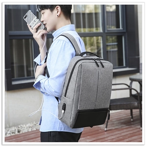 Men's grey Oxford backpack featuring an external USB charging port and spacious compartments
