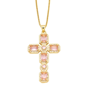 Macro view of a gold cross pendant with pink gemstones and white zircon halo detail