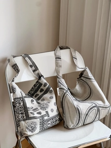 Detail of patterned cotton linen shoulder bags hanging on a chair showing fabric texture
