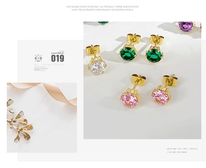 Detail of multi-color zircon stud earrings with golden claw setting on white background