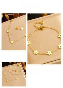 Close-up of golden flower jewelry set including necklace, bracelet and stud earrings