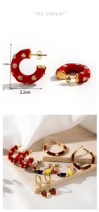 Detail view of gold-plated C-shaped earrings with red diamonds and dimensions