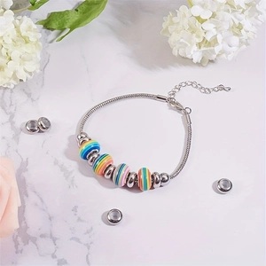 Pulsera de cadena de serpiente plateada con cuentas de rayas arcoíris sobre mármol