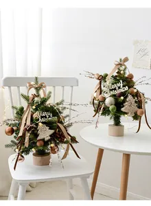 Champagne ribbon, felt balls and pine cones on a luxury mini Christmas tree with wood base