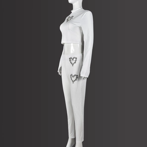 Dettaglio del set due pezzi in maglia a coste bianca con motivi a cuore di strass