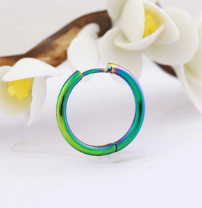 Macro shot of colorful iridescent stainless steel hoop earrings with white floral accent
